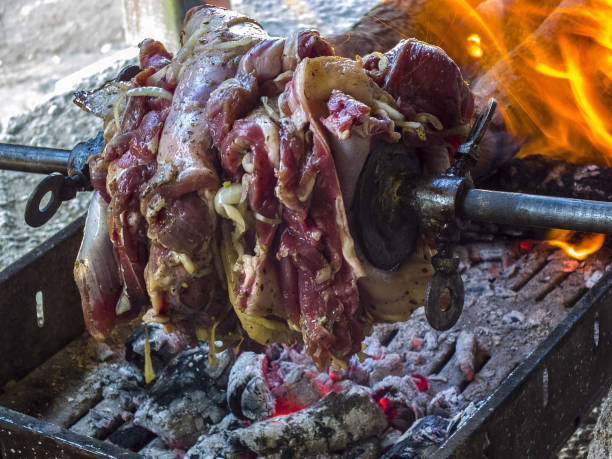 istock making Turkish kebabs, making cag kebabs, cooking meat on barbecue 874548032