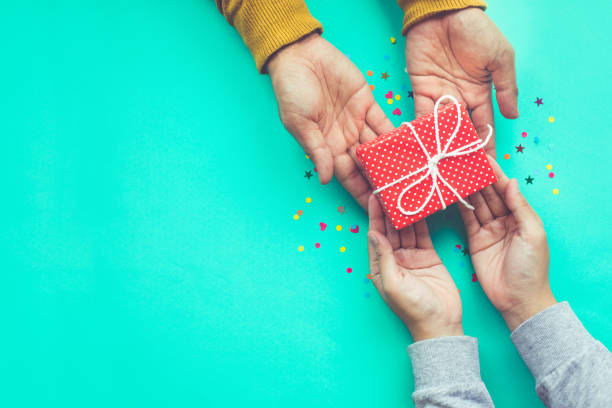 homem dá um presente à fêmea com espaço de cópia - family loving anniversary gift - fotografias e filmes do acervo