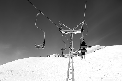 Black and white view on old chair-lift and off-piste slope at ski resort. Caucasus Mountains, mount Cheget, Elbrus region.