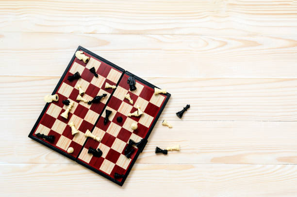 istock Chess board and some figures on the white woden background 874562648