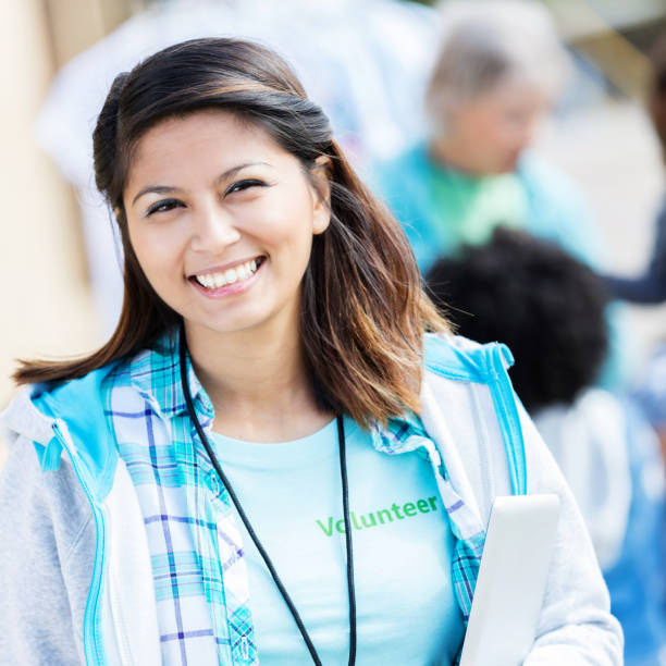 istock Cheerful volunteer coordinator smiles for camera outdoors 874565318