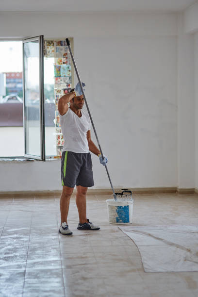 istock Ethnic worker with roller painting walls 874569420