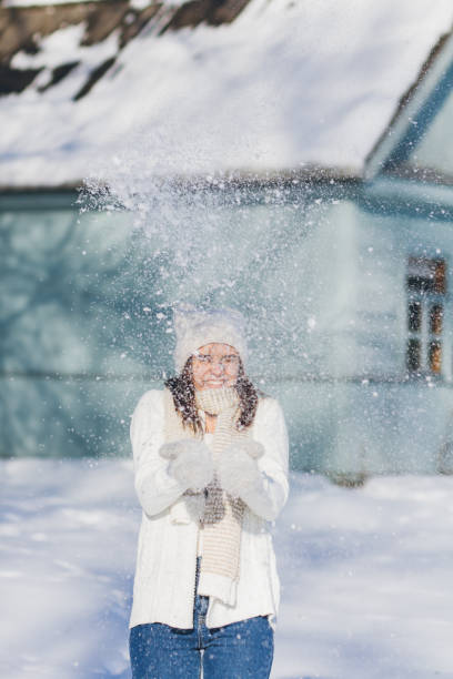 istock Girl in hat and mittens throws the snow 874572858