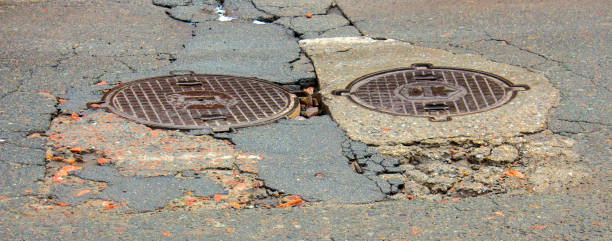 istock Waterfilled pothole on asphalted road 874576226