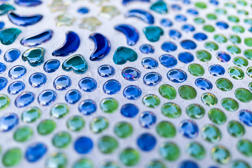 Blue and green beautiful decorative glass beads cemented in a table top