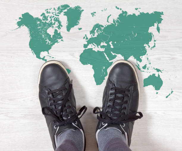 istock Black Sneakers on a World Map Outline 874577048
