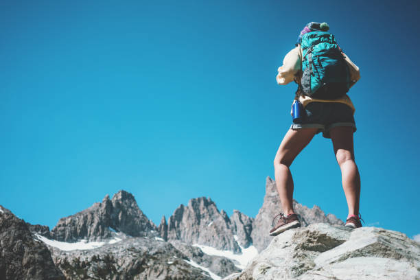 istock Woman backpacker looking at stunning mountain landscape 874579910