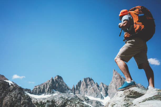 istock Man backpacker looking at stunning mountain landscape 874580110