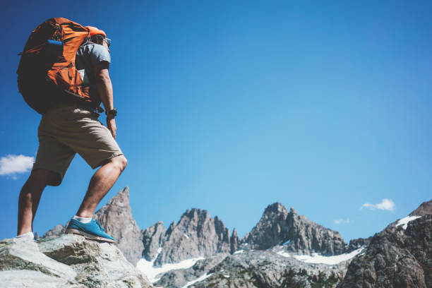 istock Man backpacker looking at stunning mountain landscape 874580116