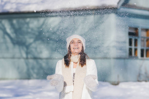 istock Girl in hat and mittens throws the snow 874580520