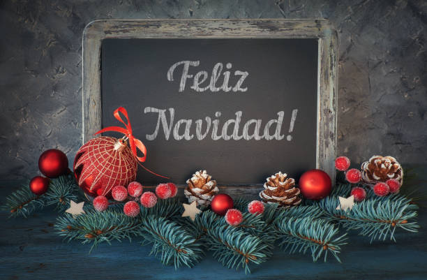 istock Decorated blackboard with Christmas greeting in Spanish on dark background 874592408