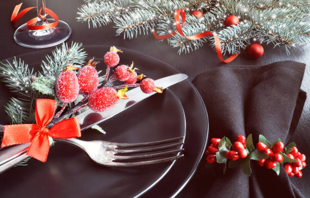 istock Black plates and cutlery with Christmas decorations on dark, close-up 874592420