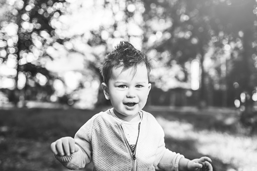 Cute liitle boy playing outdoor in the park, black and white