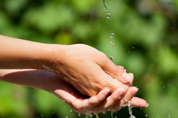 istock Woman washing hand outdoors. Hands with water splash, selective focus 874593782