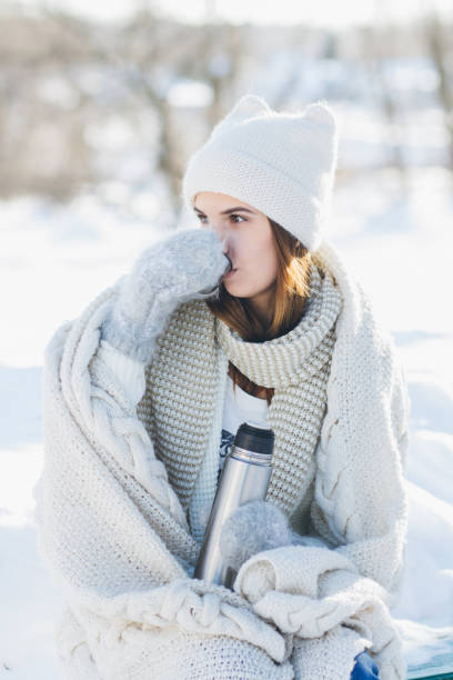 istock Girl drinking hot tea from a thermos 874594100