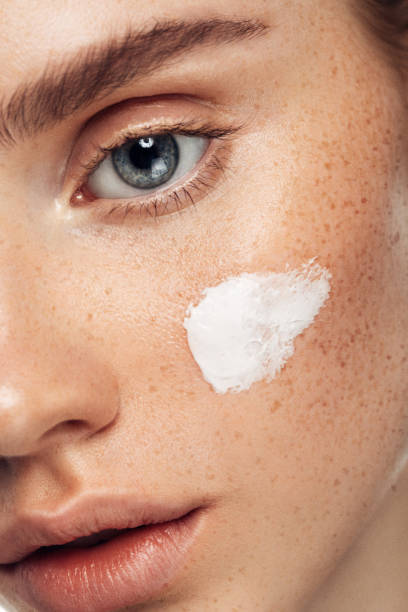 girl inflicting cream - beauty treatment skin care beauty young women imagens e fotografias de stock