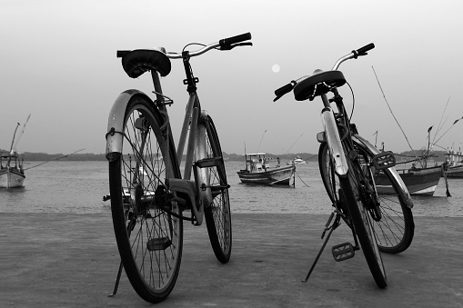 Weligama, Sri Lanka, 04-10-2017: Evening at the fishing quay - bicycles of fishermen awaiting their return from boats.