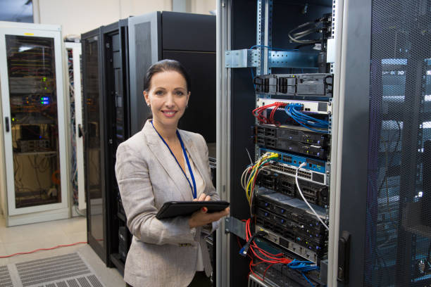 istock Female IT professional portrait in server room 874606962