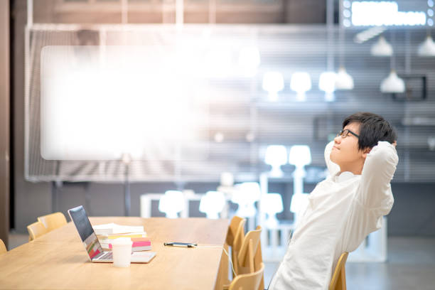istock Young Asian student man do relaxing pose during working with laptop computer in library 874616818
