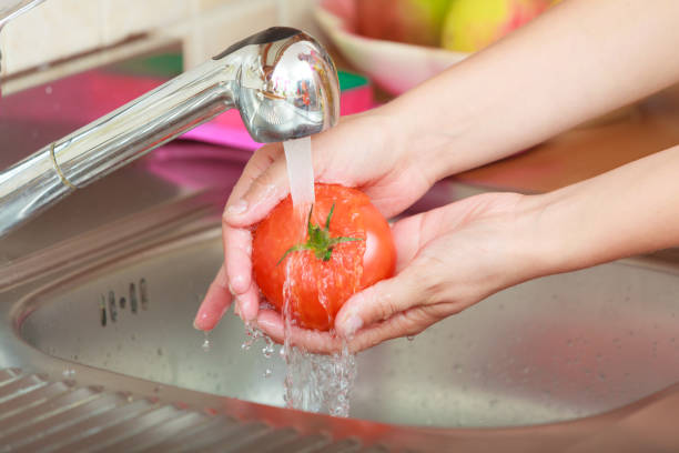 istock woman washing fresh vegetables in kitchen 874619200