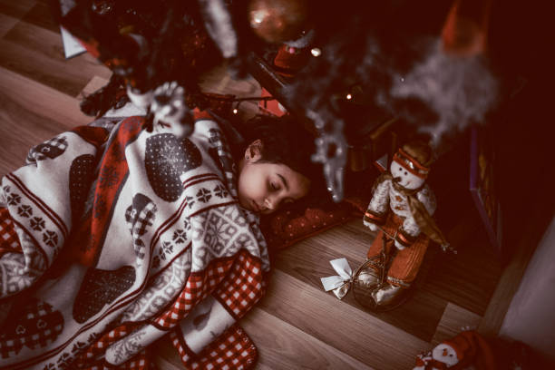 サンタさんのクリスマス ツリー フェイントあり、witing の下で、小さな女の子が眠ってください。 - 冬　睡眠 ストックフォトと画像