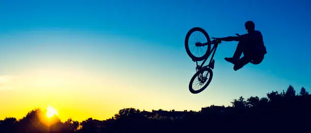 Shot of a mountain bike jump at sunset, copy space.