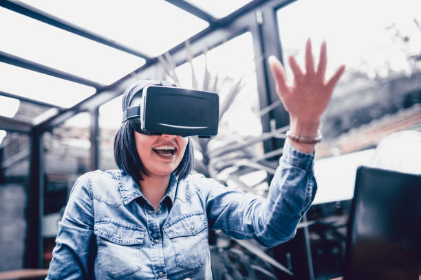 istock Young Woman Having Fun with Virtual Reality Simulator and Gesturing 874623314