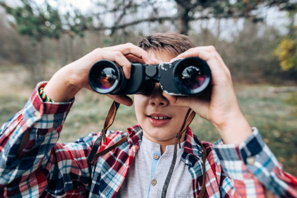 istock Boy looking in the distance with binoculars 874626348