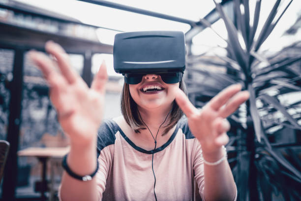 istock Young Woman Having Fun with Virtual Reality Simulator and Gesturing 874629686