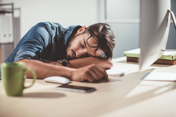 man sleeping in office - asleep on the job imagens e fotografias de stock