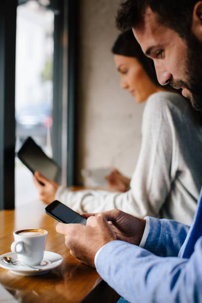 istock Couple surfing the net in cafe bar 874641290