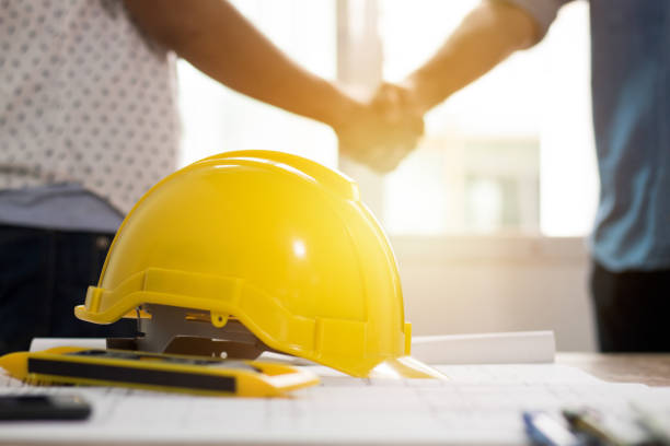istock Teamwork concept, Architecture team shaking hand in building constraction, focus at safty helmet 874641794