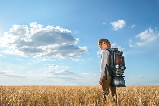 Boy with a backpack in wheat field