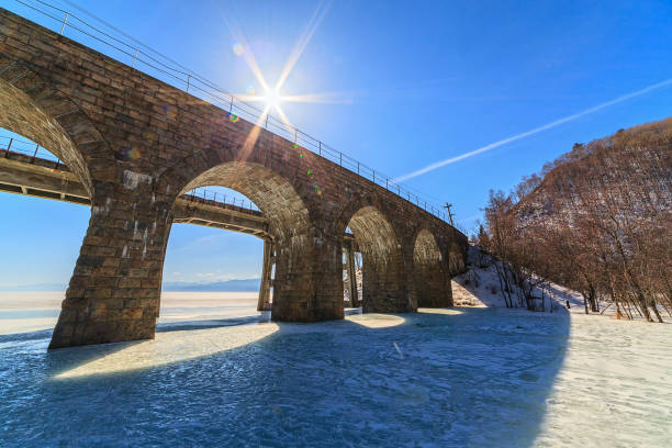 old arched railway bridge over river in winter