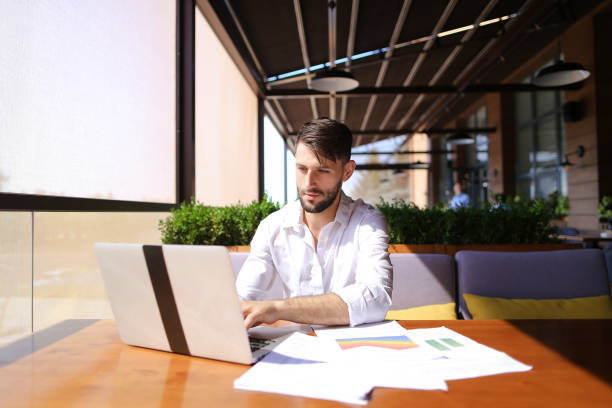 istock Caucasian businessman working with laptop and documents at table 874652260