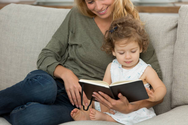 istock mother and daughter with book 874663584