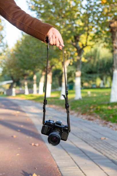 istock woman hand carrying camera walking at park trail 874665748