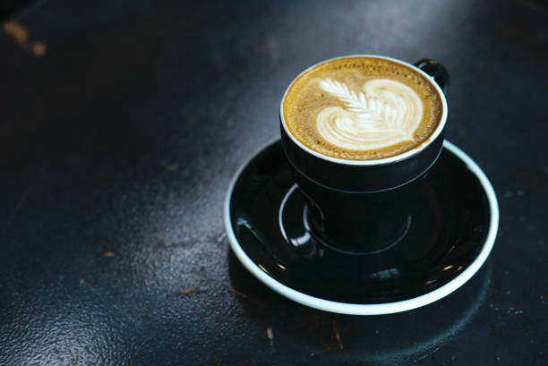 istock Hot latte coffee with black cup and dark background 874673332