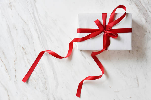 istock Top view of white gift boxes with red ribbon. 874673884
