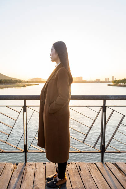 istock thoughtful woman standing on bridge during twilight 874676022