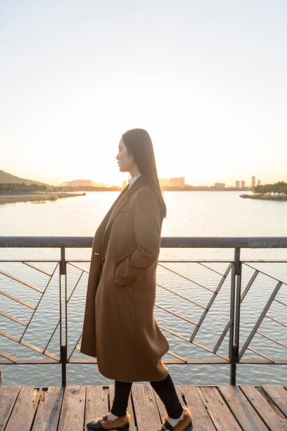 istock thoughtful woman standing on bridge during twilight 874676032