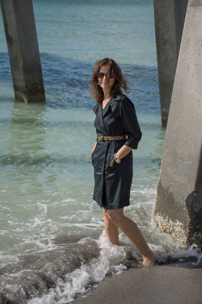 istock Woman under pier in black dress 874688840