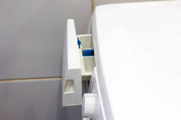 istock Woman throws laundry detergent into the washing machine close-up 874692664