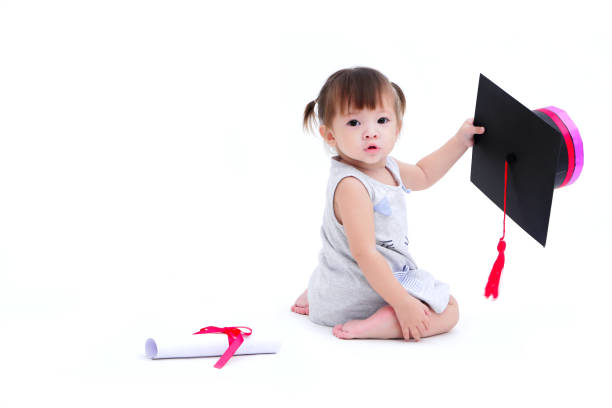 Cute girl holding graduation cap and roll diploma