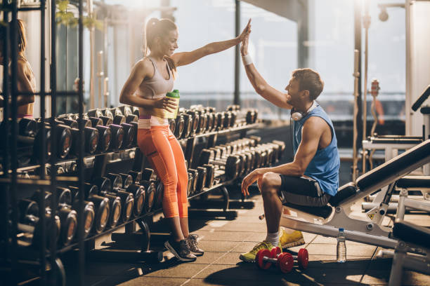 Give me high five, we have done a great training! Happy athletic couple giving each other high five after finishing sports training in a gym. resting photos stock pictures, royalty-free photos & images