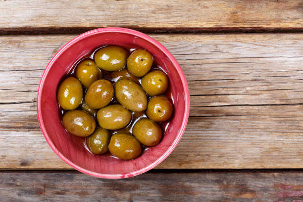 istock Olives on a wooden background. View from above 874700114
