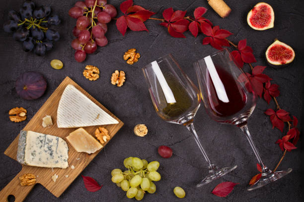 istock Red and white wine with cheese plate. Wine glasses with cheese,  grapes, figs and nuts. 874707832