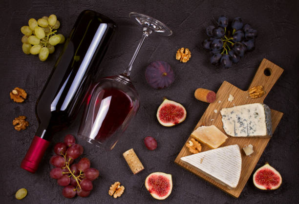 istock Red and white wine with cheese plate. Wine glasses with cheese,  grapes, figs and nuts. 874710568