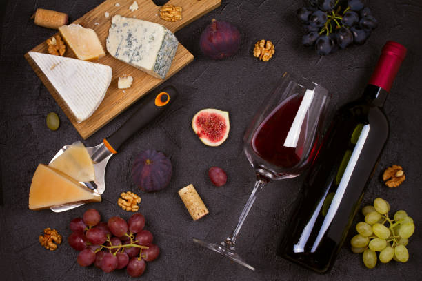 istock Red and white wine with cheese plate. Wine glasses with cheese,  grapes, figs and nuts. 874711000