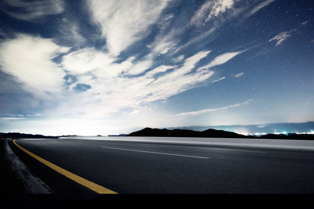 istock empty rural asphalt road with green hill in star sky 874711058